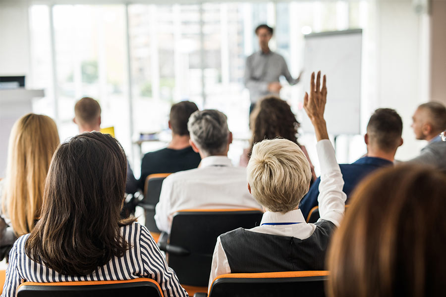 woman raising hand in class